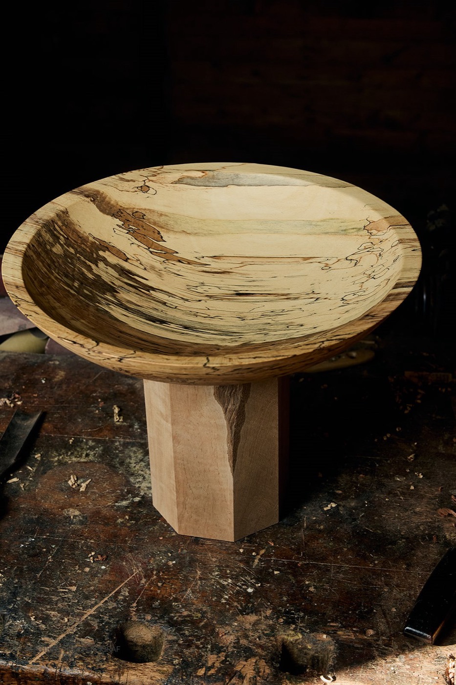 Flache Platte aus gestockter Buche mit schwarzen Linien auf einem Holzsockel